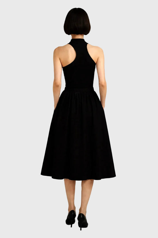 Person wearing a black dress on a gray background
