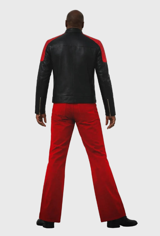 Person wearing a black leather jacket with red accents and red pants on a gray background