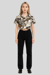 Woman in Sailuc floral cropped shirt and black pants, showcasing luxury modern fashion.