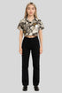 Woman in Sailuc floral cropped shirt and black pants, showcasing luxury modern fashion.