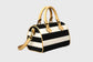 Black and white striped handbag with accents on a gray background