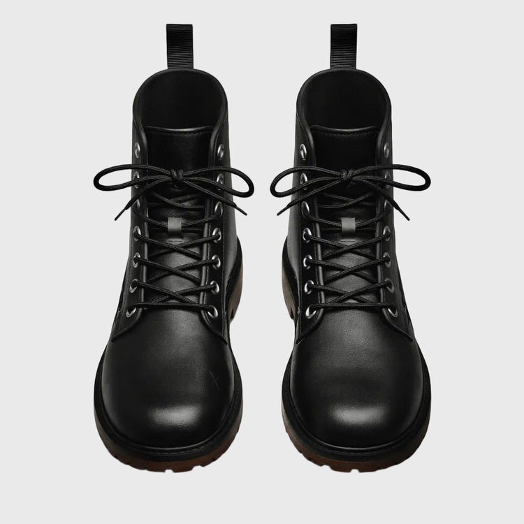 Pair of black leather boots on a gray background