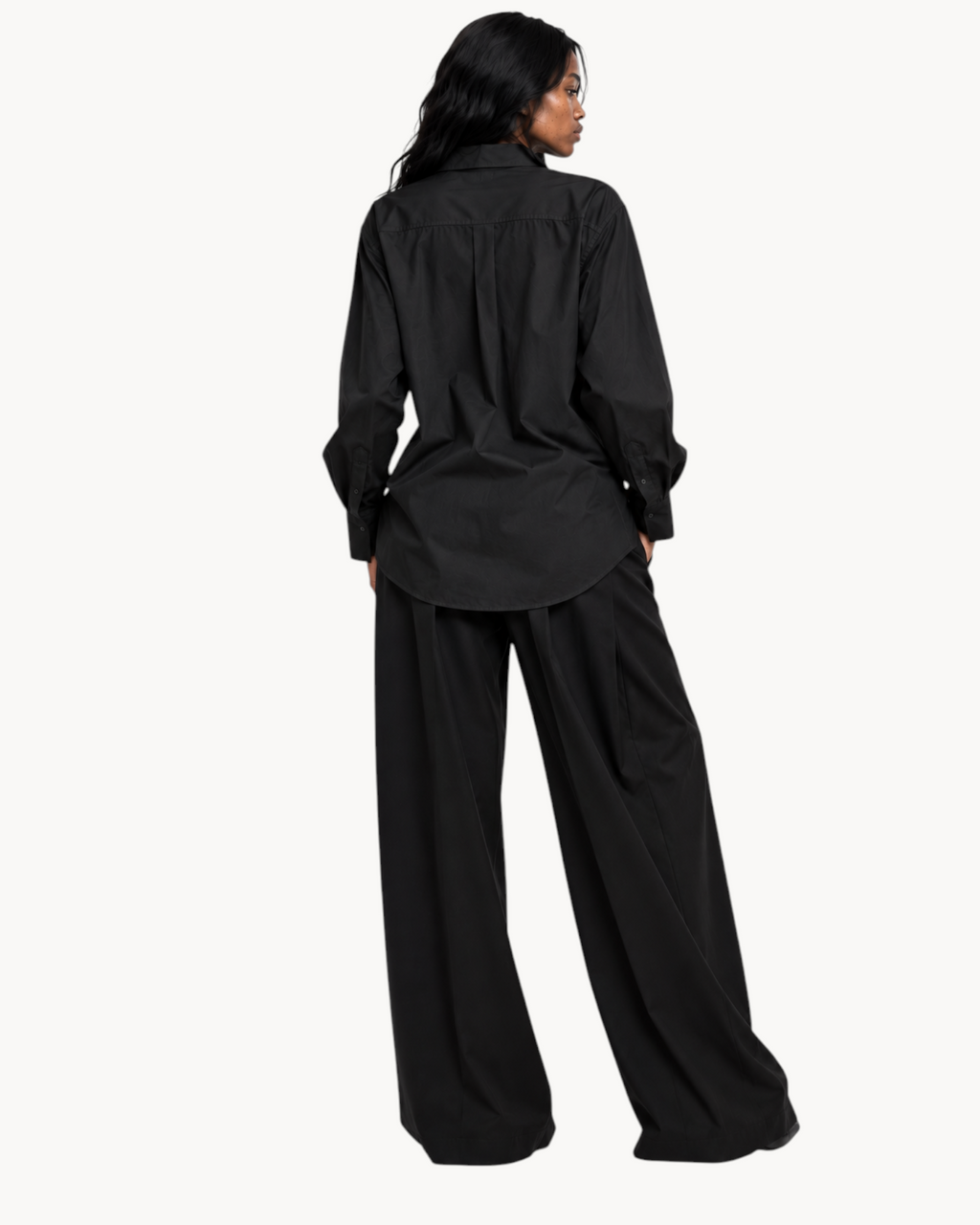 Model wearing a black Sailuc Linea longline shirt with a classic collar and regular fit, back view.