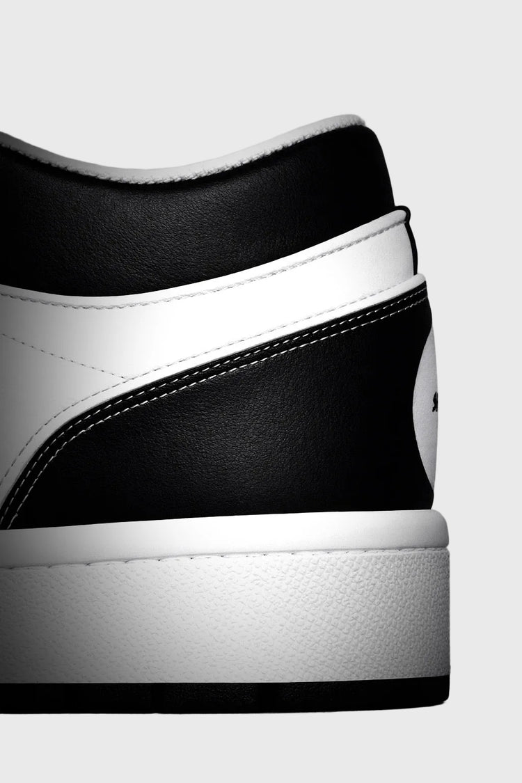Close-up of a black and white sneaker on a gray background