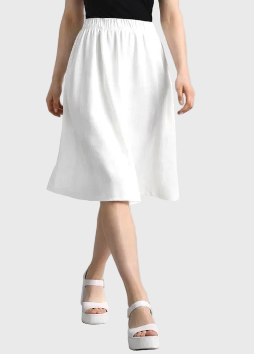 White skirt worn by a person on a plain background