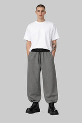 Man wearing Sailuc oversized white t-shirt, gray drawstring pants, and black boots