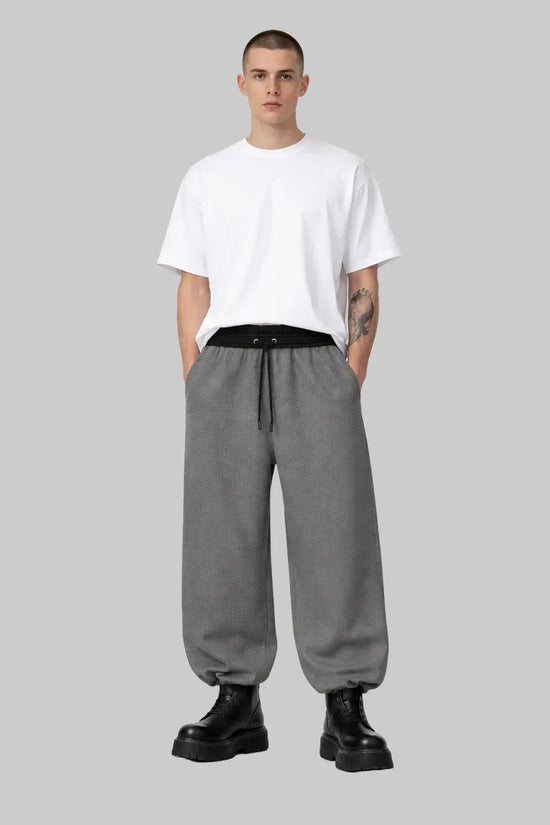 Man wearing Sailuc oversized white t-shirt, gray drawstring pants, and black boots