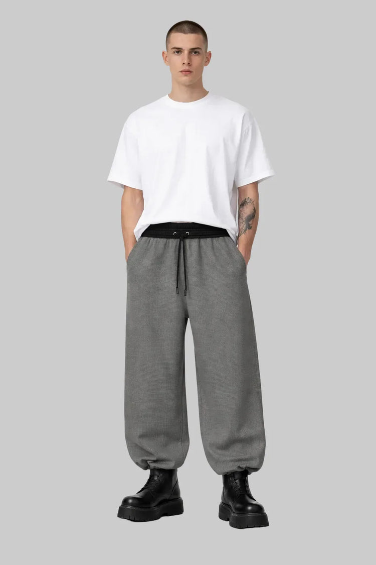 Man wearing Sailuc oversized white t-shirt, gray drawstring pants, and black boots