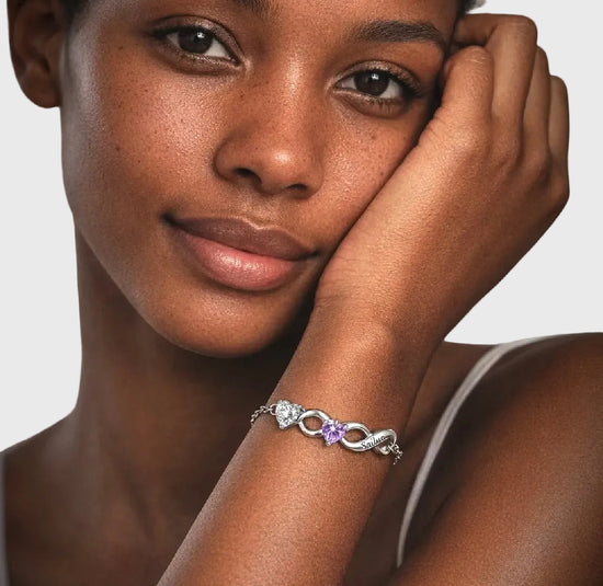 Woman wearing a silver bracelet with a astrology gemstone on a neutral background