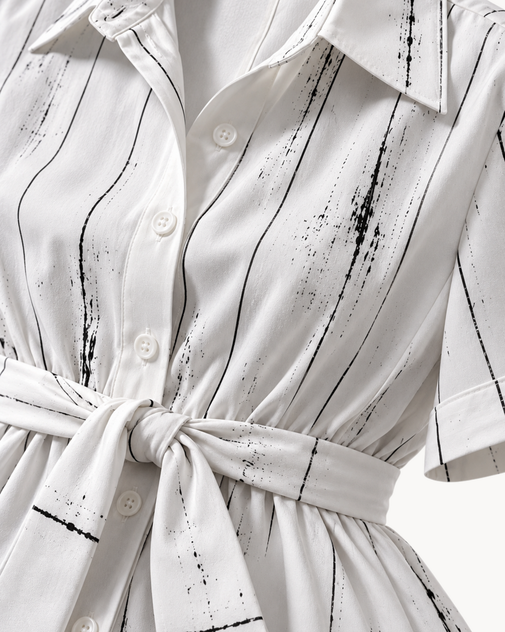 Sailuc Liora shirt dress in white with black vertical brushstroke print, featuring a button front and waist tie.