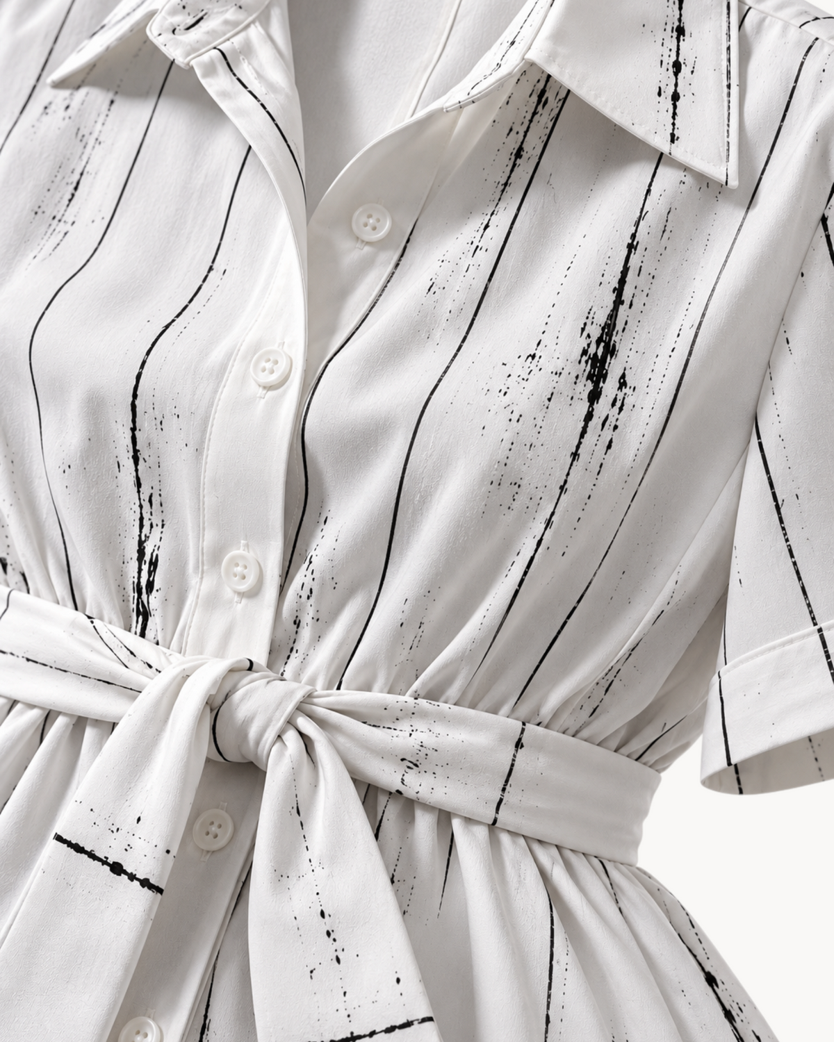 Sailuc Liora shirt dress in white with black vertical brushstroke print, featuring a button front and waist tie.