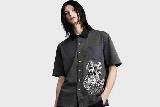 Person wearing a gray shirt with a graphic design on a plain background