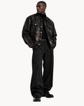 A model wearing a Sailuc Strata collared jacket with a distressed black and red pattern over a black turtleneck.