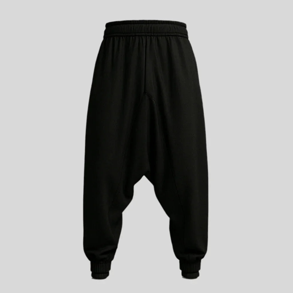 Sailuc black drop-crotch jogger pants with elastic waistband and cuffed hems on gray background