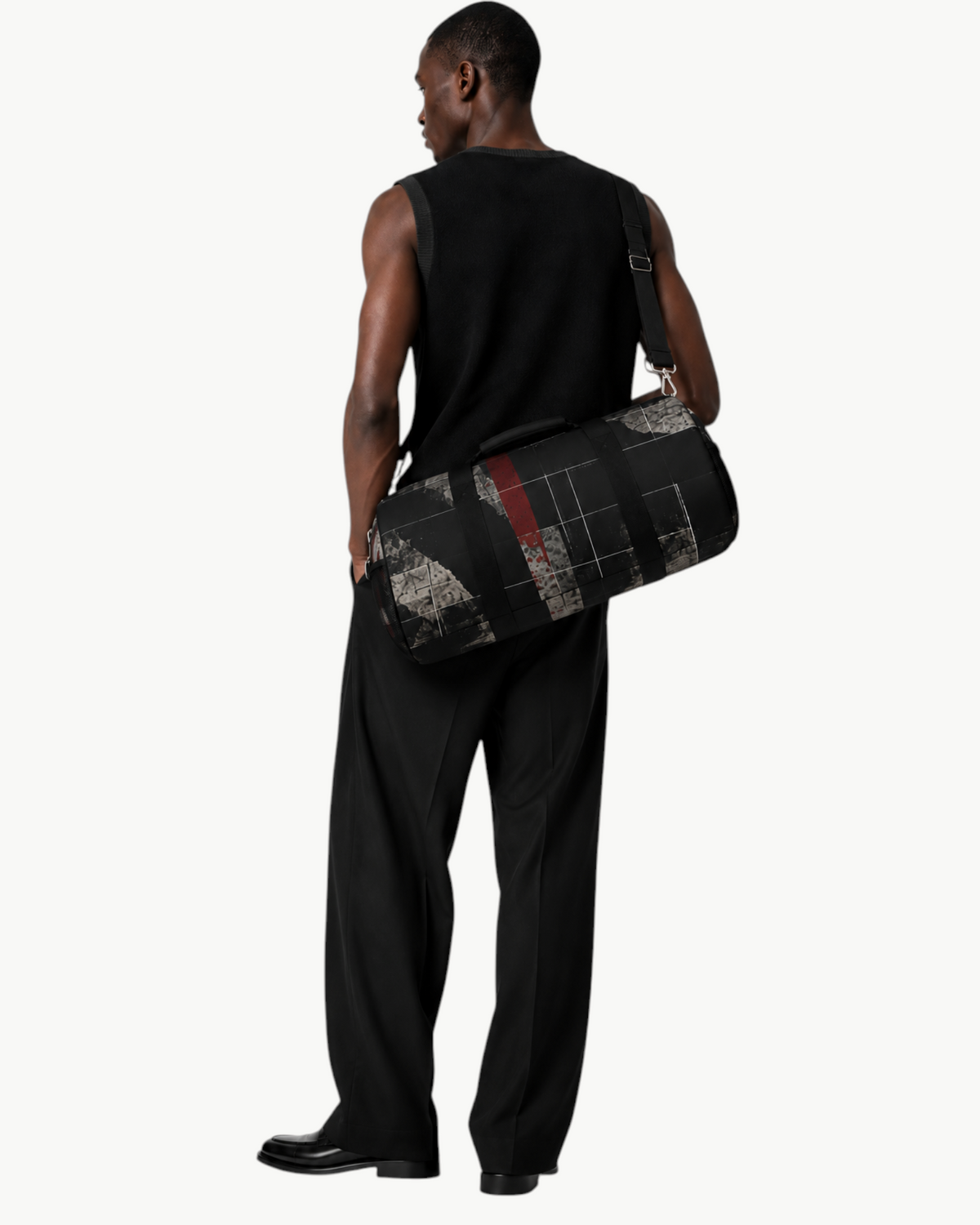 A model carrying a Sailuc Obscura duffle bag with dark abstract art on Oxford canvas over his shoulder.