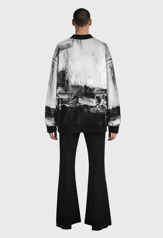 Person wearing a black and white patterned shirt with a gray background