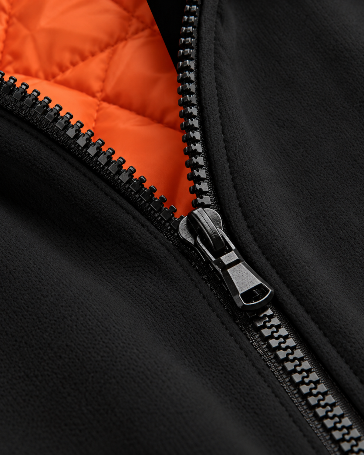Sailuc Noma fleece jacket featuring a black Hacci fleece exterior, a bright orange quilted lining, and a zip closure.