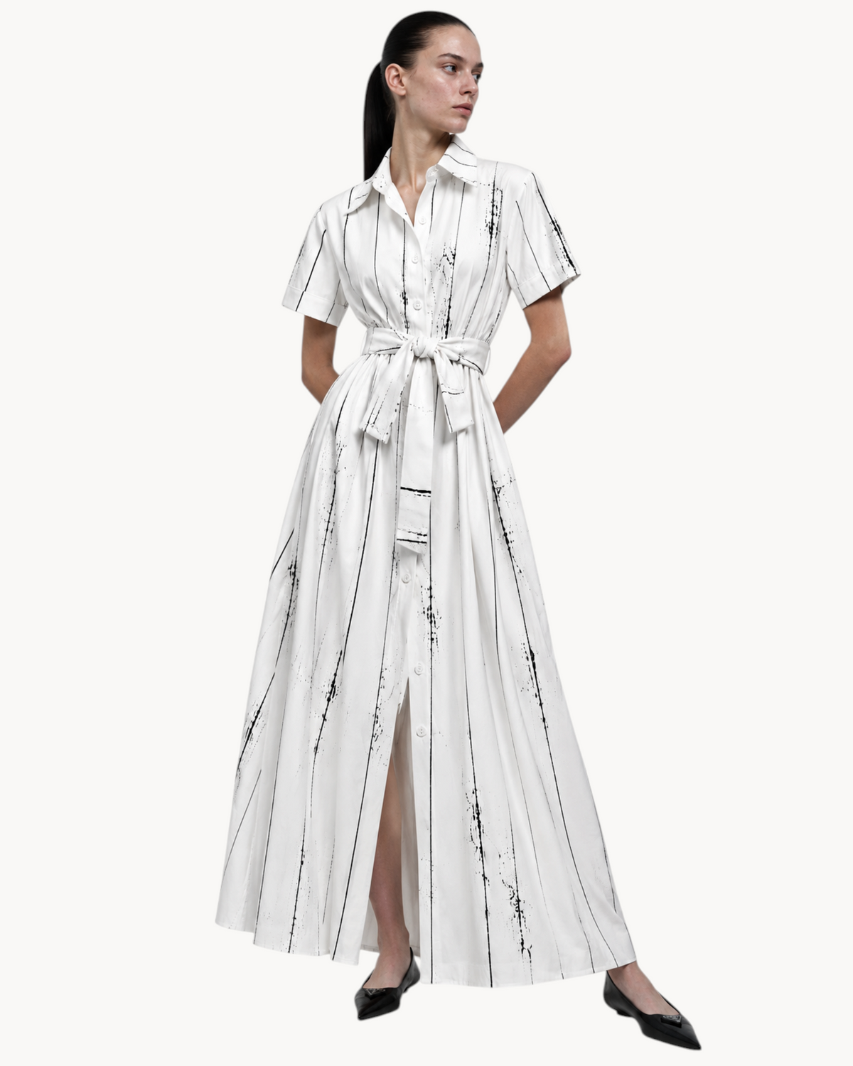 Sailuc Liora shirt dress in white with black vertical abstract stripes, featuring a button front and waist tie.