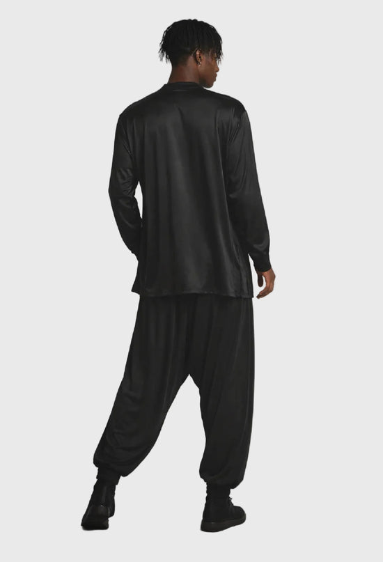 Person wearing a black outfit on a gray background