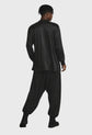 Person wearing a black outfit on a gray background