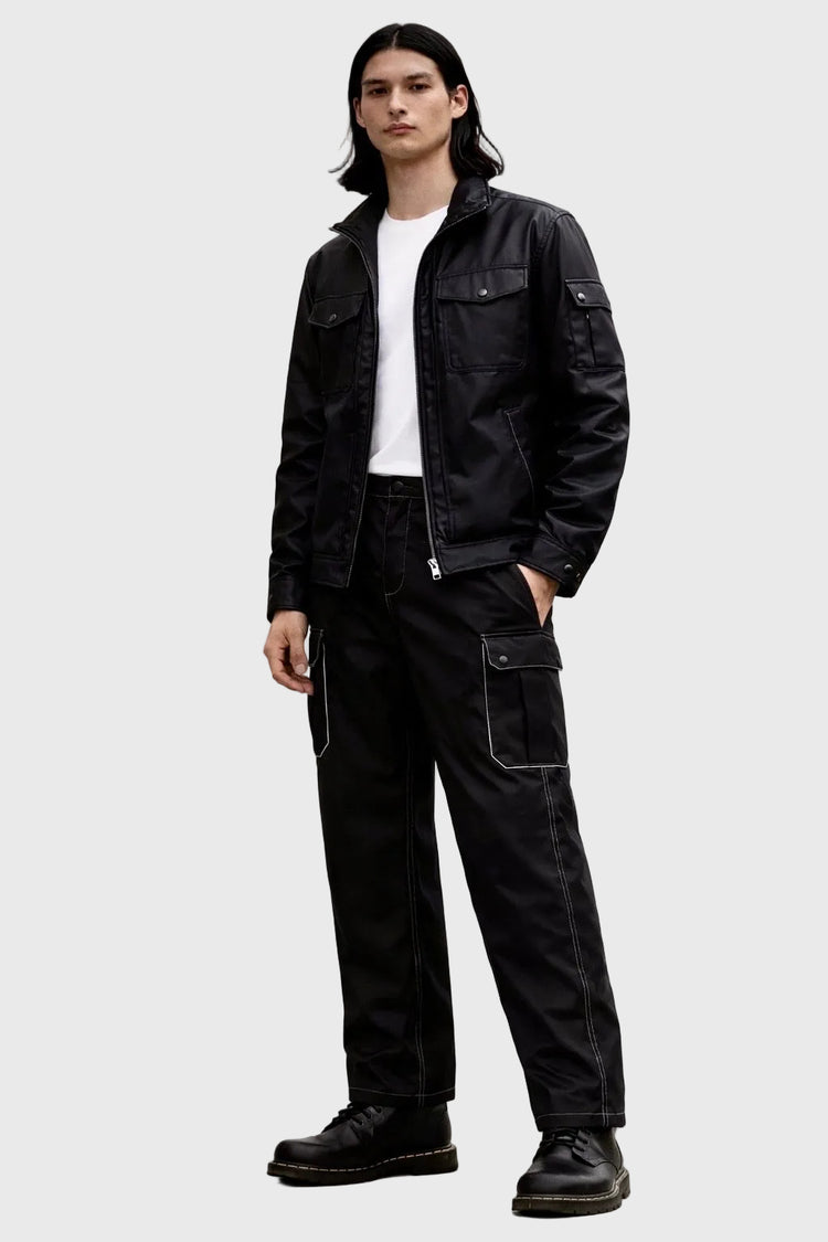Person wearing a black jacket and pants on a white background