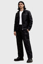 Person wearing a black jacket and pants on a white background
