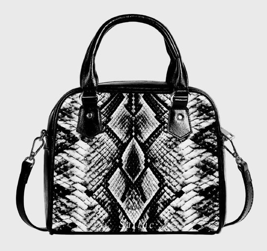 Black and white patterned handbag on a gray background