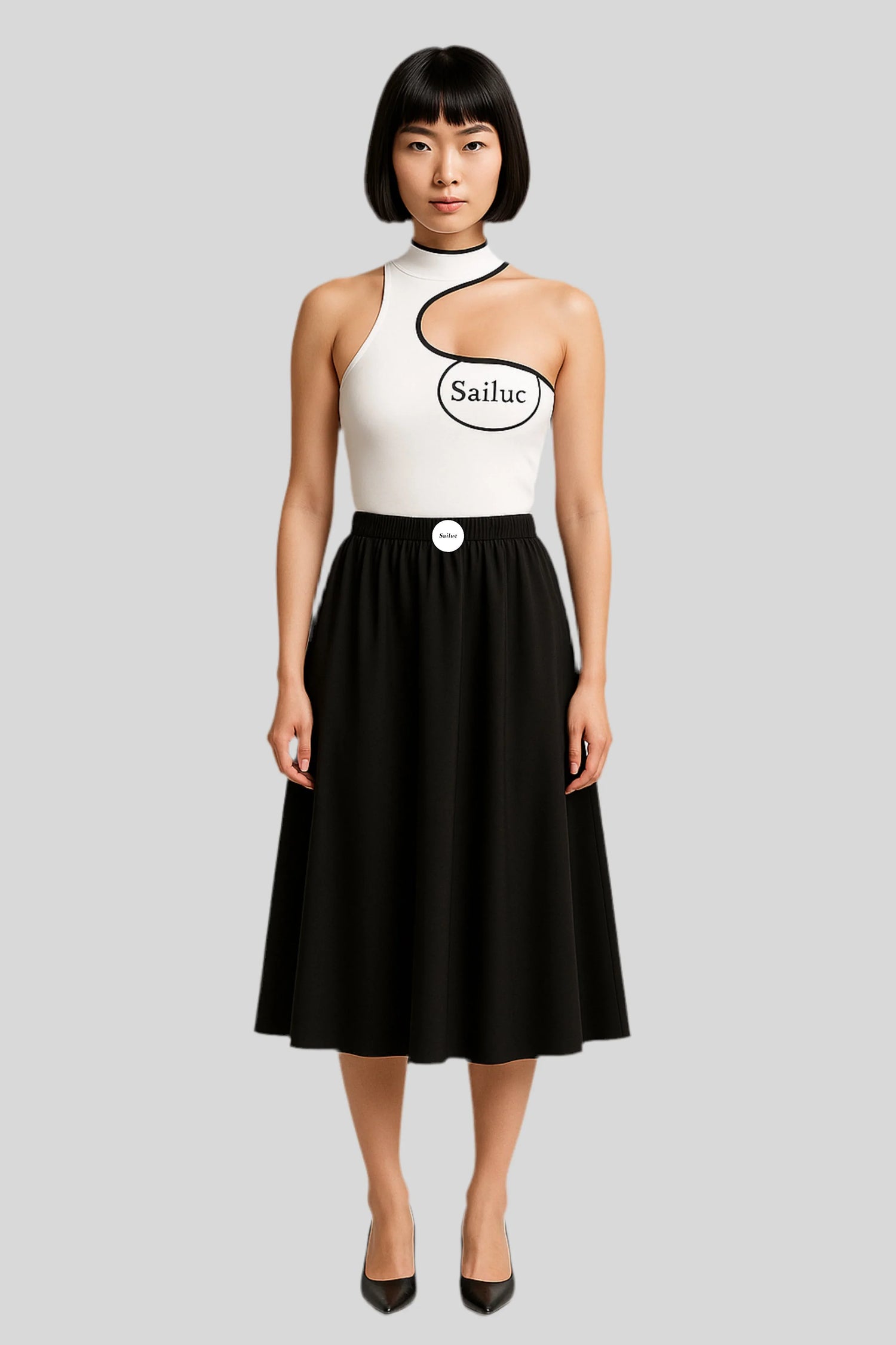 Woman in luxury Sailuc black skirt and white asymmetric top with logo, standing on gray background