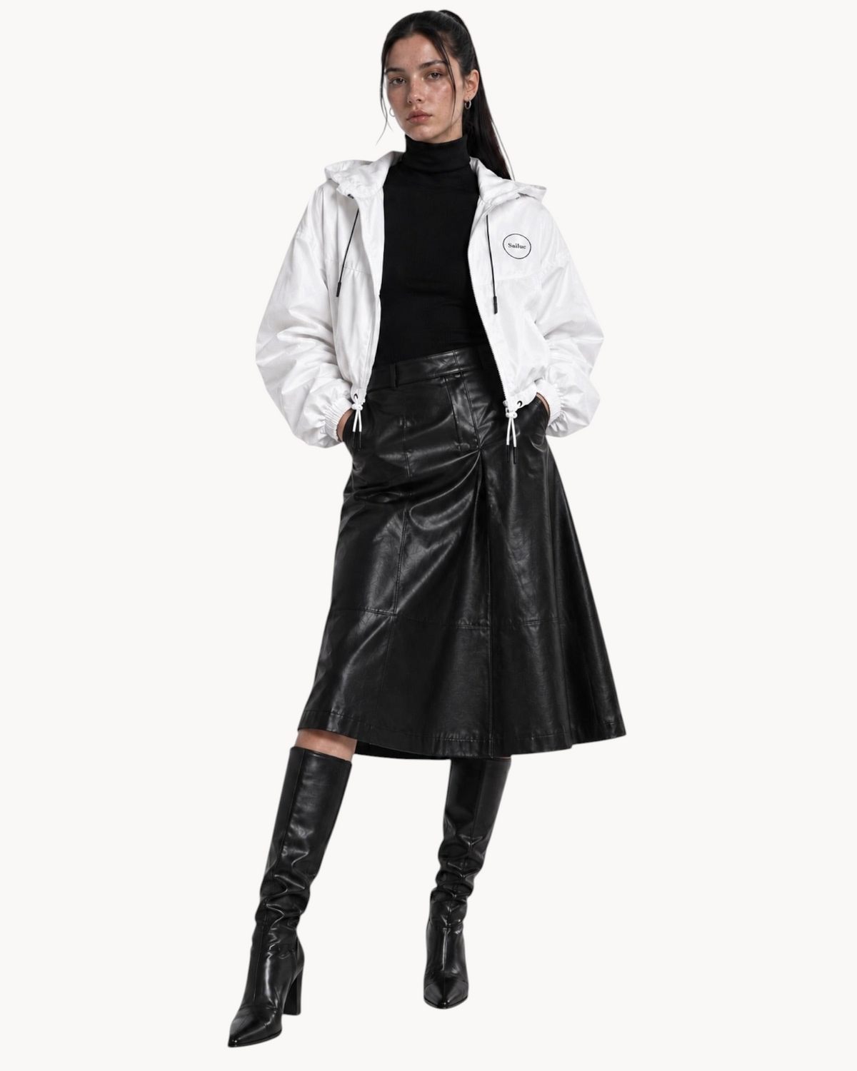 Model wearing a Sailuc white cropped windbreaker with a hood, half-zip, and drawcord waist over a black outfit.