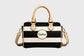 Black and white striped handbag with beige accents on a gray background