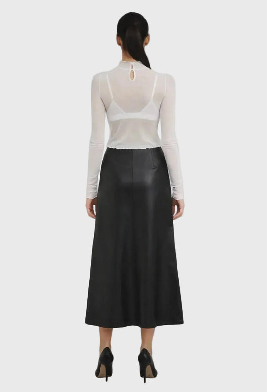 Person wearing a black skirt and white sheer top on a gray background
