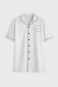 White shirt with black trim and branding on a gray background