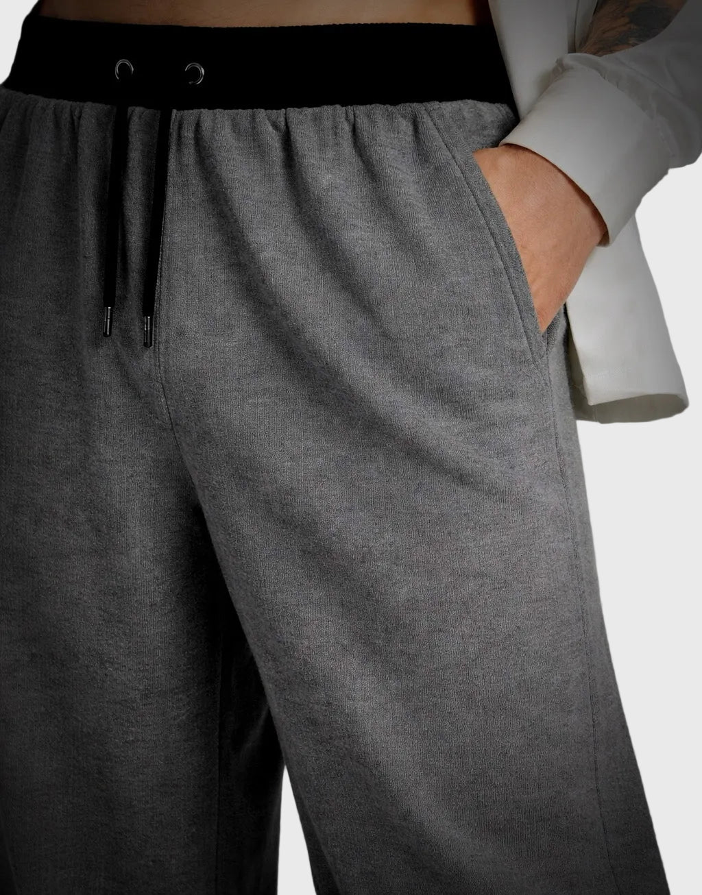 Gray sweatpants with a black waistband on a neutral background