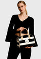 Woman holding a black and white striped handbag with Sailuc branding on a gray background