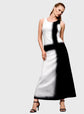 Woman wearing a black and white dress against a gray background