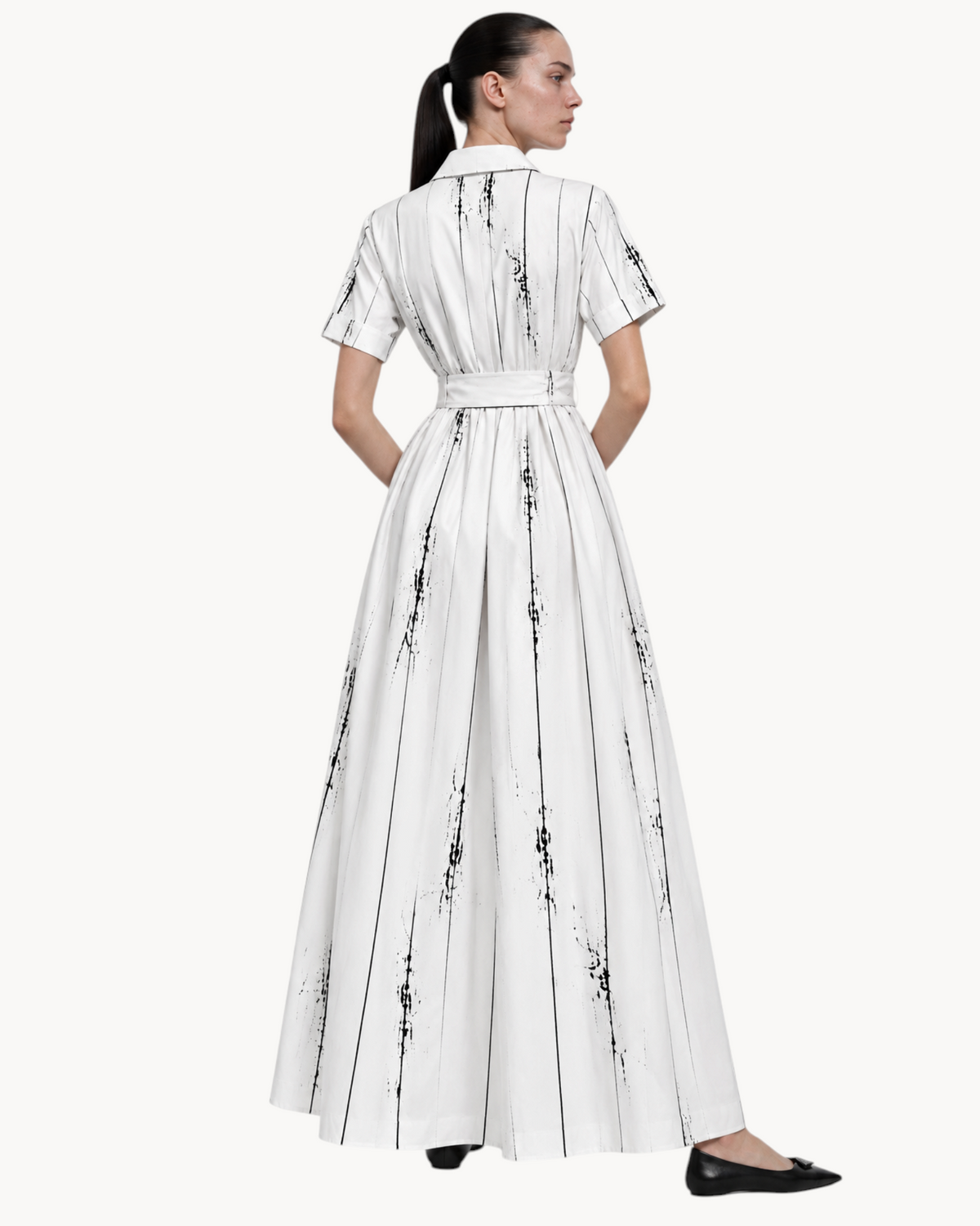 Back view of a Sailuc Liora shirt dress in white with a black vertical brushstroke print, featuring a waist tie.