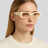 Woman wearing cream rectangular sunglasses and ivory top, Sailuc luxury fashion accessory