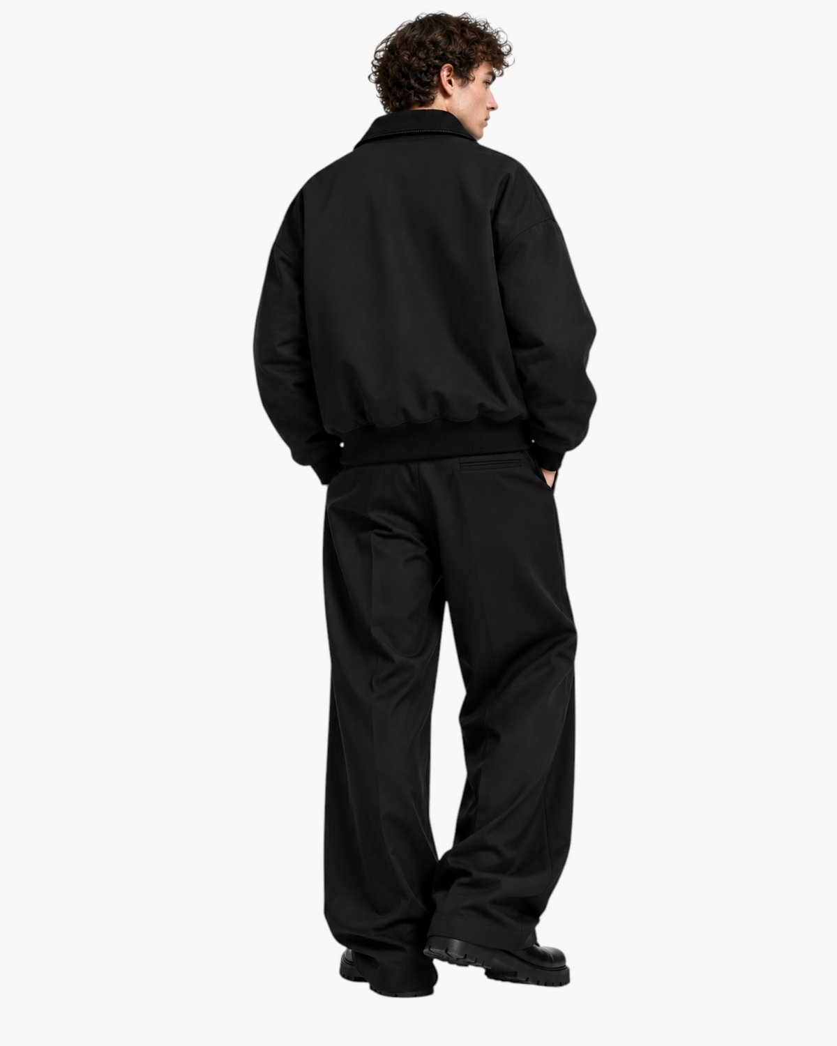 Back view of a model wearing the Sailuc Noma fleece jacket in black with ribbed cuffs and hem.