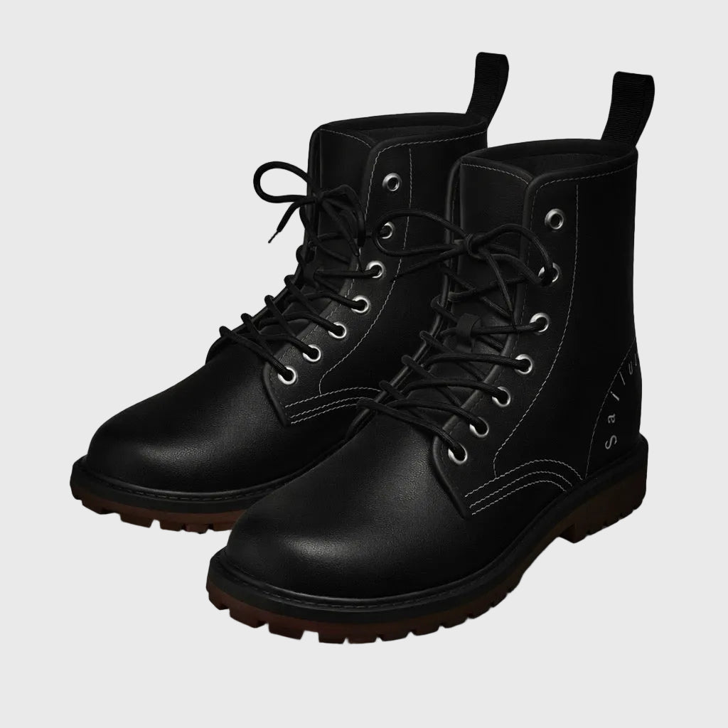 Pair of black leather boots on a gray background