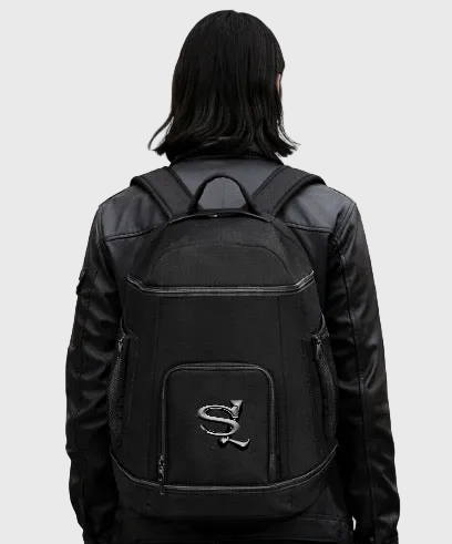 Person wearing a black backpack with a logo on a gray background