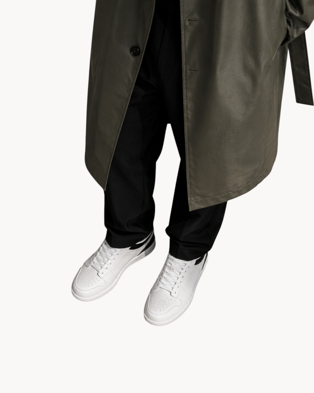 Overhead view of Sailuc Linea white sneakers styled with black trousers and a long olive coat.